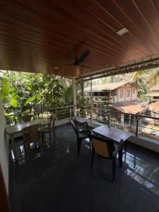 een patio met een tafel en stoelen op een balkon bij Sadhana Homestay in Revadanda
