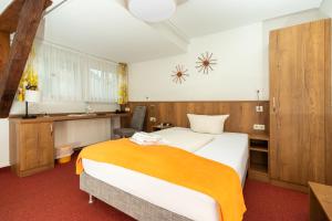 a hotel room with a bed and a desk at Wanderhotel Sonnebergbaude in Waltersdorf