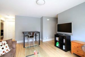 QE Park Garden suite 3BR 1.5Ba في فانكوفر: غرفة معيشة بها أريكة وتلفزيون