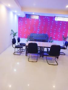 Habitación con mesa, sillas y sofá en Roomshala 002 Rose Residency Near Yashobhoomi en Nueva Delhi