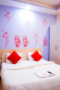 a bedroom with two beds with red pillows at Roomshala 002 Rose Residency Near Yashobhoomi in New Delhi