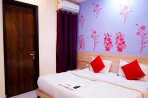 1 dormitorio con 2 camas y almohadas rojas en Roomshala 002 Rose Residency Near Yashobhoomi en Nueva Delhi