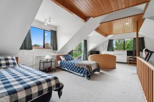 a bedroom with two beds and a staircase at So Good On Sargood - Wanaka Holiday Home in Wanaka