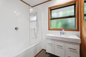 a bathroom with a sink and a shower and a window at So Good On Sargood - Wanaka Holiday Home in Wanaka +15 photos