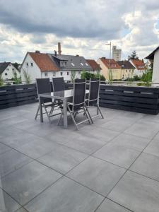 a patio with chairs and a table on a roof at Apartmenthaus Çelik Bielefeld Süd Senne in Bielefeld