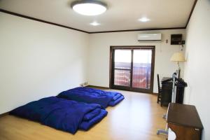 una camera da letto con due grandi cuscini blu sul pavimento di 上田屋　半田館 a Handa