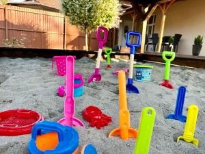 a pile of plastic toys in the sand in a yard at Éden Vendégház Gyula in Gyula