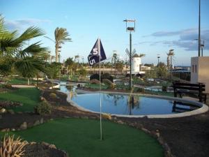 a golf course with a putting green with a flag at El Castillo Golf Salinas-wifi in La Guirra