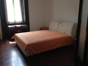 a bedroom with a bed and a chair and a window at Casa Lisa in Como