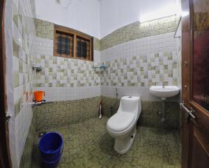 a bathroom with a toilet and a sink at Meadow Heaven Home Stay in Munnar