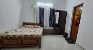 a bedroom with a bed and a window and a mirror at Meadow Heaven Home Stay in Munnar