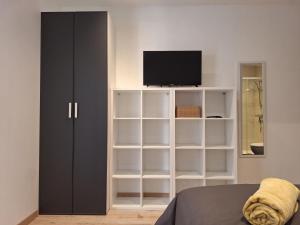 a bedroom with a book shelf and a television at Chambre GUSTAV in Agen