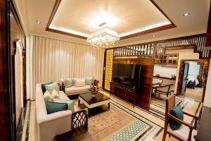 a living room with a couch and a television at Taj Tirupati in Tirupati