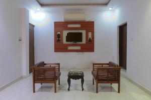 a living room with two chairs and a tv at Embassy Suites in New Delhi