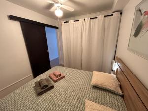 ein Schlafzimmer mit einem Bett mit zwei Hausschuhen darauf in der Unterkunft Appt Cambria - à 2 min du Lagon de la Saline-les-bains in Saint-Paul