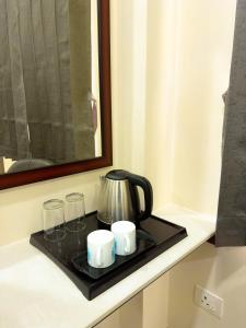 a coffee pot and glasses on a tray on a counter at TULIP HOMES in Coimbatore