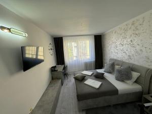 a bedroom with a bed and a television in it at TS Room in Curtea de Argeş