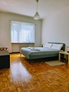 a bedroom with a bed and a wooden floor at Sailing Apartment Lugano in Lugano