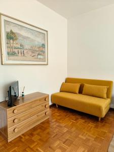 a living room with a yellow couch and a wooden coffee table at Sailing Apartment Lugano in Lugano