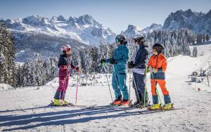 een groep van vier personen op ski's in de sneeuw bij Appartements Pension Elfi in Gosau