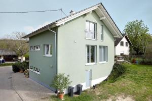 uma casa verde e branca com uma entrada em Ferienwohnung In Der Weinig em Sasbach am Kaiserstuhl