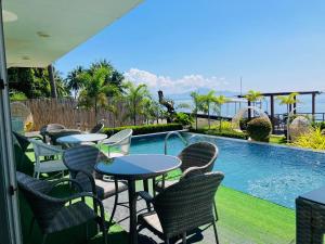a patio with tables and chairs next to a swimming pool at Paradiso Rito in Mabini