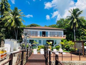 a house on the beach with a statue on a wooden bridge at Paradiso Rito in Mabini