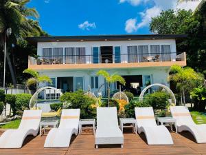 a group of chairs and tables in front of a house at Paradiso Rito in Mabini