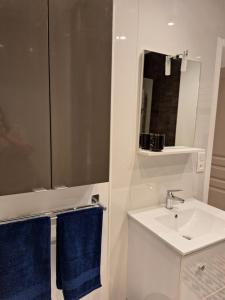 a white bathroom with a sink and a mirror at Chambre NINA in Agen