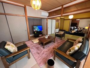 een woonkamer met 2 banken en een tv bij Iojima BeachHouse - Vacation STAY 97622v in Nagasaki