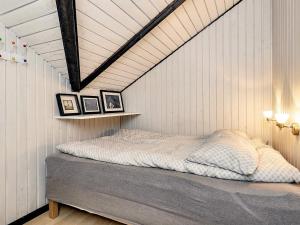 ein Schlafzimmer mit einem Bett in einer weißen Wand in der Unterkunft Holiday home Hals LXXIII in Hals