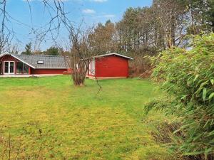 ein roter Schuppen in einem Hof neben einem Haus in der Unterkunft Holiday home Hals LXXIII in Hals