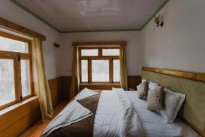 Schlafzimmer mit einem großen Bett und einem Fenster in der Unterkunft Hotel Lumbini in Leh