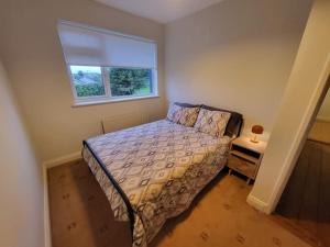 a small bedroom with a bed and a window at Carrigaline Delightful Home in Carrigaline