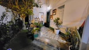 La Casona Hospedaje في ليما: مدخل إلى منزل به نباتات الفخار