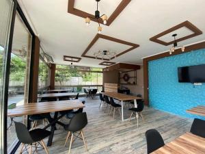 a dining room with tables and chairs and a blue wall at Villa NiNo in Kobuleti
