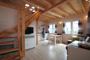 a woman standing in the kitchen of a tiny house at Nowabobolin domki in Bobolin