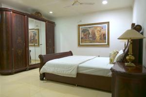 a bedroom with a bed and a painting on the wall at Embassy Suites in New Delhi