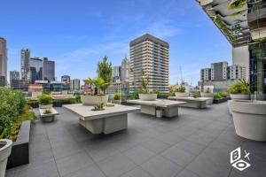 een patio met tafels en potplanten op een gebouw bij REST COLLECTION Highrise Studio Apartment at Melbourne Central in Melbourne