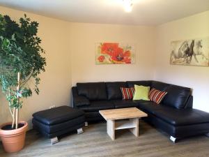 uma sala de estar com um sofá de couro preto e uma mesa em Bio-Bauernhof Simonbauer em Ramsau am Dachstein
