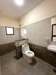 a bathroom with a toilet and a sink at TULIP HOMES in Coimbatore