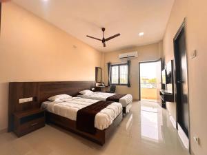 a bedroom with two beds and a ceiling fan at TULIP HOMES in Coimbatore