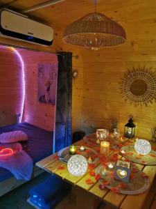 una stanza con un tavolo con candele e una stanza con un letto di Magnifique chalet Atypique avec Spa sous bulle privatif a Lanthenay
