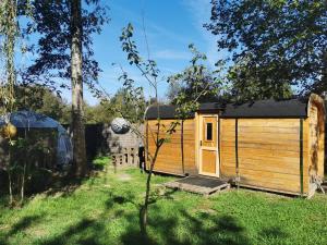 una cabina di legno con una porta nell'erba di Magnifique chalet Atypique avec Spa sous bulle privatif a Lanthenay