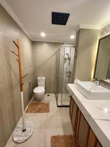 a bathroom with a shower and a toilet and a sink at 2 BR Lime Penthouse, Tagaytay Highlands in Tagaytay +3 photos