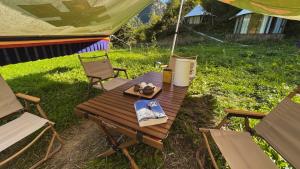 a picnic table with a tent in the grass at 九寨沟阿布氇孜民宿Jiuzhaigou Valley Abluzi B&B in Jiuzhaigou