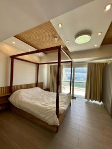 a bedroom with a canopy bed and a large window at 2 BR Lime Penthouse, Tagaytay Highlands in Tagaytay
