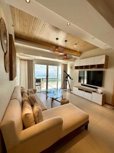 uma sala de estar com um sofá e uma televisão em 2 BR Lime Penthouse, Tagaytay Highlands em Tagaytay