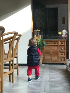 懐柔区にあるGarden hotel under the great wallのテレビの前に立っている小さな子供
