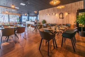 a restaurant with wooden floors and tables and chairs at Hotel Tierra in Don Benito